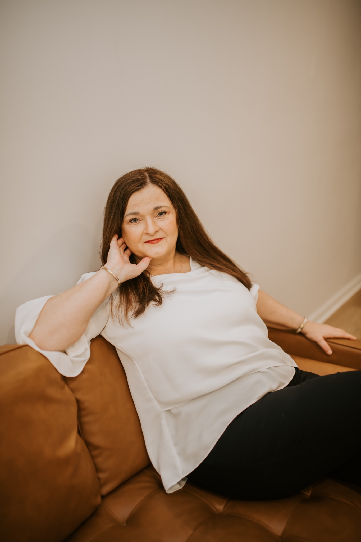 Angela Conner Foland seated in a warm, reflective portrait